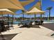 Resort-style community pool with shaded seating areas and palm trees for a relaxing outdoor experience at 15911 W Montana De Oro Dr, Surprise, AZ 85387