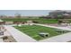 Outdoor cornhole setup with synthetic grass and benches, great for recreation and relaxation at 15911 W Montana De Oro Dr, Surprise, AZ 85387