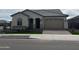 Well-kept single-story home showcasing a tile roof, lush green lawn, and neat brick driveway at 15911 W Montana De Oro Dr, Surprise, AZ 85387