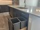 Kitchen island with a sink and cabinet with trash containers offering convenient waste disposal at 15911 W Montana De Oro Dr, Surprise, AZ 85387