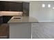 Modern kitchen with dark cabinetry, an island with seating, and stainless steel appliances at 15911 W Montana De Oro Dr, Surprise, AZ 85387