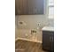Laundry room features gray cabinets, a utility sink, and modern appliances, ready for easy laundry days at 15911 W Montana De Oro Dr, Surprise, AZ 85387