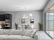 Bright living room featuring gray walls, stylish furnishings, and sliding glass doors leading to the backyard at 15911 W Montana De Oro Dr, Surprise, AZ 85387