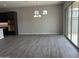 Open-concept living room with dark cabinets, wood floors and a modern lighting fixture at 15911 W Montana De Oro Dr, Surprise, AZ 85387