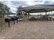 Outdoor covered picnic area with grill and seating on brick pavers in a relaxing community at 15911 W Montana De Oro Dr, Surprise, AZ 85387
