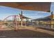 Modern playground featuring climbing structures with covered seating nearby for parents to relax at 15911 W Montana De Oro Dr, Surprise, AZ 85387