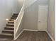 Carpeted staircase with white railing leading upstairs, complemented by wood-look flooring at 15911 W Montana De Oro Dr, Surprise, AZ 85387