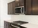 Close up of a kitchen with quartz countertops, stainless steel appliances, and dark cabinetry at 16077 W Remuda Dr, Surprise, AZ 85387