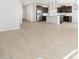 Open concept living space with wood-look tile floors and a kitchen with stainless steel appliances at 16077 W Remuda Dr, Surprise, AZ 85387
