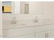 Bathroom featuring double sinks, white cabinets, and modern faucets at 16080 W Prickly Pear Trl, Surprise, AZ 85387