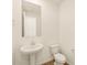 Clean half bathroom with a pedestal sink, white toilet, mirror, and wood-look tile flooring at 16080 W Prickly Pear Trl, Surprise, AZ 85387