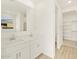 Bright bathroom with double sinks, large mirrors, and a view to the walk-in closet at 16080 W Prickly Pear Trl, Surprise, AZ 85387