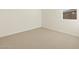 A bright bedroom with a window allowing natural light to fill the space and neutral carpeting at 16080 W Prickly Pear Trl, Surprise, AZ 85387