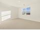 Bright, neutral-toned bedroom featuring plush carpeting and a window with blinds at 16080 W Prickly Pear Trl, Surprise, AZ 85387
