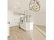 Bright kitchen featuring white cabinets, stainless appliances, a kitchen island, and a modern chandelier at 16080 W Prickly Pear Trl, Surprise, AZ 85387
