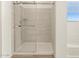 Shower with neutral ceramic tiles, glass door, and modern fixtures at 16080 W Prickly Pear Trl, Surprise, AZ 85387