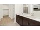 Bathroom featuring double sink vanity, neutral tile floors, and a separate shower at 16081 W Remuda Dr, Surprise, AZ 85387