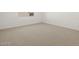 This bedroom features neutral carpet, white walls and trim, and a window at 16081 W Remuda Dr, Surprise, AZ 85387