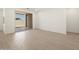 Large, empty room featuring wood-look tile and access to a backyard patio at 16081 W Remuda Dr, Surprise, AZ 85387