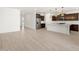 Open floor plan with wood-look tile flooring leading to a kitchen with stainless steel appliances at 16081 W Remuda Dr, Surprise, AZ 85387