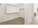 Walk-in closet featuring neutral carpet, white walls, and metal racks for clothing at 16081 W Remuda Dr, Surprise, AZ 85387