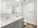 Bathroom with double vanity sinks, white countertops, and wood-look tile floor at 17809 W Elm St, Goodyear, AZ 85395