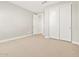 Bedroom features fresh carpet, light-colored walls, and double-door closet at 17809 W Elm St, Goodyear, AZ 85395