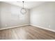 Bright dining room features wood-look tile flooring and a modern orb chandelier at 17809 W Elm St, Goodyear, AZ 85395