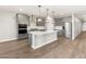 Bright kitchen boasts gray cabinets, stainless steel appliances, an island, and wood-look floors, blending style and functionality at 17809 W Elm St, Goodyear, AZ 85395