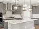 Modern kitchen features sleek gray cabinets, stainless steel appliances, a stylish range hood, and a central island at 17809 W Elm St, Goodyear, AZ 85395