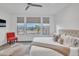 Bright bedroom featuring a king bed, three windows with views, and a red accent chair at 18332 E Spring Valley Ct, Rio Verde, AZ 85263
