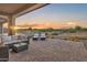 Expansive outdoor patio featuring comfortable seating with a breathtaking sunset view at 18332 E Spring Valley Ct, Rio Verde, AZ 85263