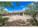 Expansive backyard featuring desert landscaping, shade trees, and a covered patio at 19245 W Pasadena Ave, Litchfield Park, AZ 85340