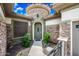 Elegant entryway with stone accents, a decorative front door, and lush landscaping, creating a welcoming first impression at 19245 W Pasadena Ave, Litchfield Park, AZ 85340
