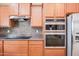 Close up of kitchen with stainless steel double ovens and modern appliances at 19245 W Pasadena Ave, Litchfield Park, AZ 85340