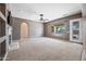 Spacious living room with carpet flooring, a cozy fireplace, and ample natural light, perfect for relaxation and entertaining at 19245 W Pasadena Ave, Litchfield Park, AZ 85340