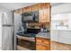 Functional kitchen features wooden cabinetry, stainless steel appliances, and adjacent laundry area at 2119 N Recker Rd, Mesa, AZ 85215