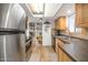 Well-lit kitchen with stainless steel appliances, a pantry, tile floors, and wooden cabinets at 2119 N Recker Rd, Mesa, AZ 85215