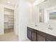 Bright bathroom featuring a double sink vanity with white countertops and a spacious walk-in closet at 24467 W Grenadine Rd, Buckeye, AZ 85326
