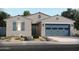 Charming single-story home with a two-car garage, desert landscaping, and blue accents at 24471 W Grenadine Rd, Buckeye, AZ 85326