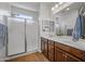 Bright bathroom with a double sink vanity, walk in shower, and wood look flooring at 301 S 225Th Ave, Buckeye, AZ 85326