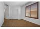 Empty bedroom with wood look floors, window with shutter, and double door closet at 301 S 225Th Ave, Buckeye, AZ 85326