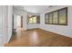 Well-lit bedroom with wood floors, window shutters, and access to a covered patio at 301 S 225Th Ave, Buckeye, AZ 85326