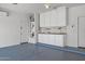 Garage interior with epoxy flooring, utility sink, storage, and water heater at 301 S 225Th Ave, Buckeye, AZ 85326