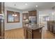Bright kitchen featuring an island with granite countertop, wooden cabinets, and stainless steel refrigerator at 301 S 225Th Ave, Buckeye, AZ 85326