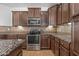 Modern kitchen with dark cabinets, stainless steel appliances, and granite countertops at 301 S 225Th Ave, Buckeye, AZ 85326