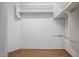 Walk-in closet with wood look flooring and custom white shelves and clothes rods at 301 S 225Th Ave, Buckeye, AZ 85326