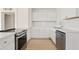 Contemporary kitchen featuring sleek countertops, white cabinets, modern appliances and light wood-style flooring at 311 N Henkel --, Mesa, AZ 85201