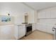 Bright open kitchen with white cabinetry, modern appliances, and light flooring, connected to a spacious living area at 311 N Henkel --, Mesa, AZ 85201