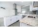 Updated white kitchen featuring stainless steel appliances, gray subway tile backsplash, and granite countertops at 3128 N 40Th Ave, Phoenix, AZ 85019